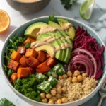 Overhead view of a healthy and colorful Buddha bowl packed with fresh vegetables, quinoa, and chickpeas.