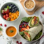 Colorful assortment of easy vegan lunch recipes including a buddha bowl, wrap, and soup on a light wooden background.